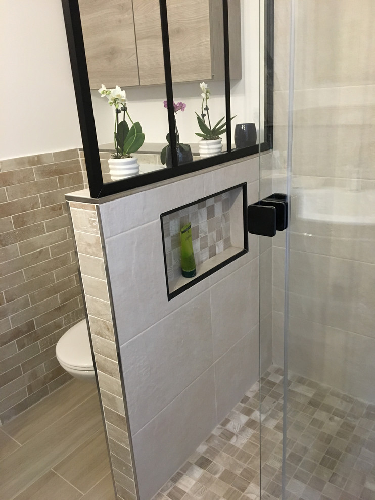 Photo of a small traditional master bathroom in Paris with flat-panel cabinets, light wood cabinets, a curbless shower, a wall-mount toilet, beige tile, ceramic tile, beige walls, light hardwood floors, a trough sink, terrazzo benchtops, beige floor, a sliding shower screen, white benchtops, a niche, a single vanity, a floating vanity and brick walls.