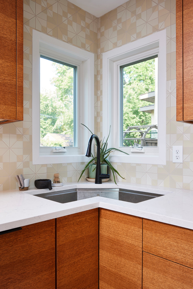 Photo of a small contemporary u-shaped kitchen/diner in Minneapolis with a single-bowl sink, flat-panel cabinets, medium wood cabinets, engineered stone countertops, beige splashback, ceramic splashback, black appliances, terrazzo flooring, a breakfast bar, white floors and white worktops.