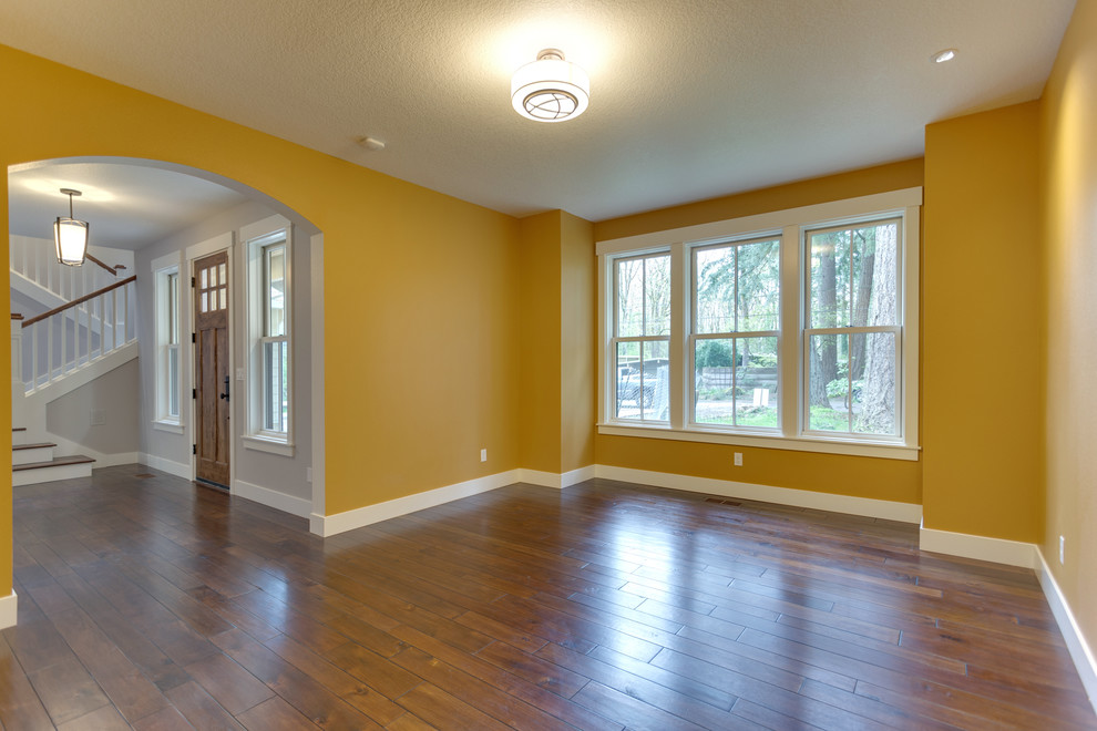 This is an example of a mid-sized country separate dining room in Salt Lake City with yellow walls, dark hardwood floors and brown floor.