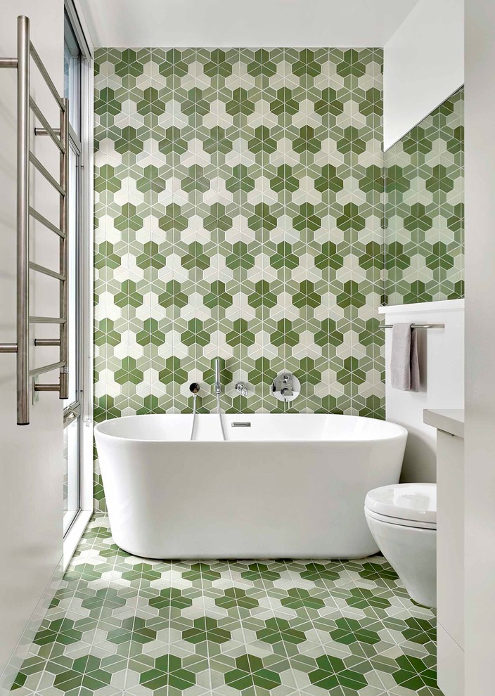Example of a trendy master green tile and multicolored tile multicolored floor freestanding bathtub design in San Francisco with multicolored walls