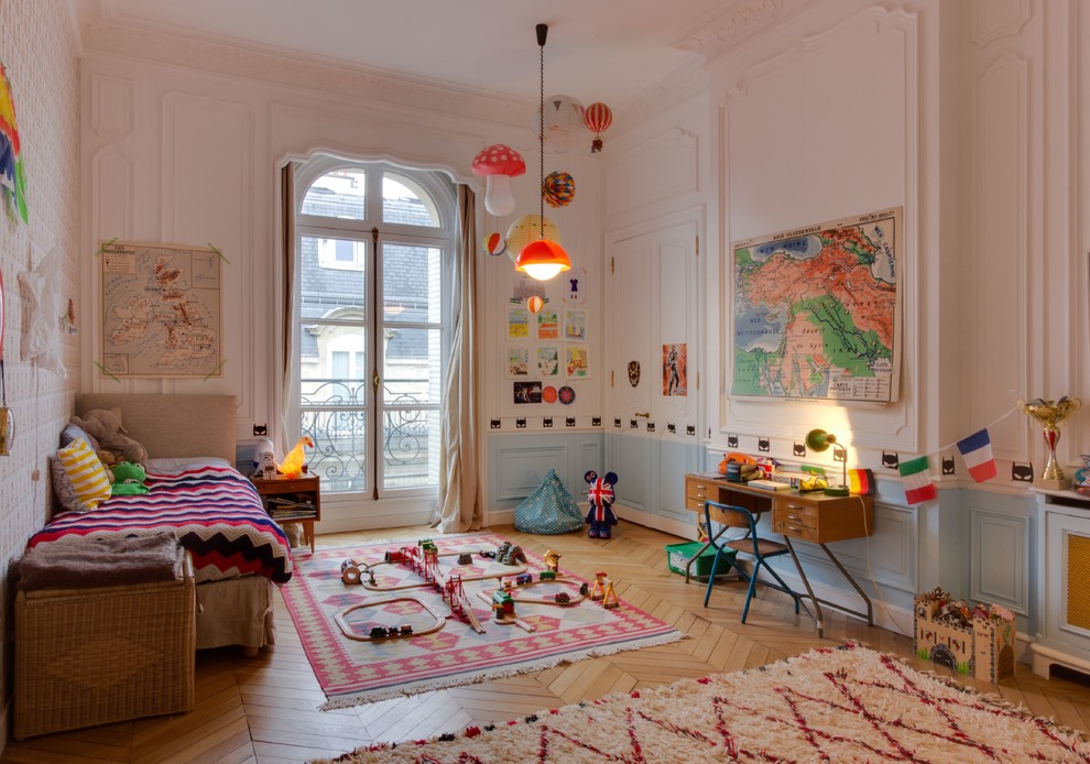 Photo of a contemporary kids' room for girls in Paris with white walls, medium hardwood floors and brown floor.