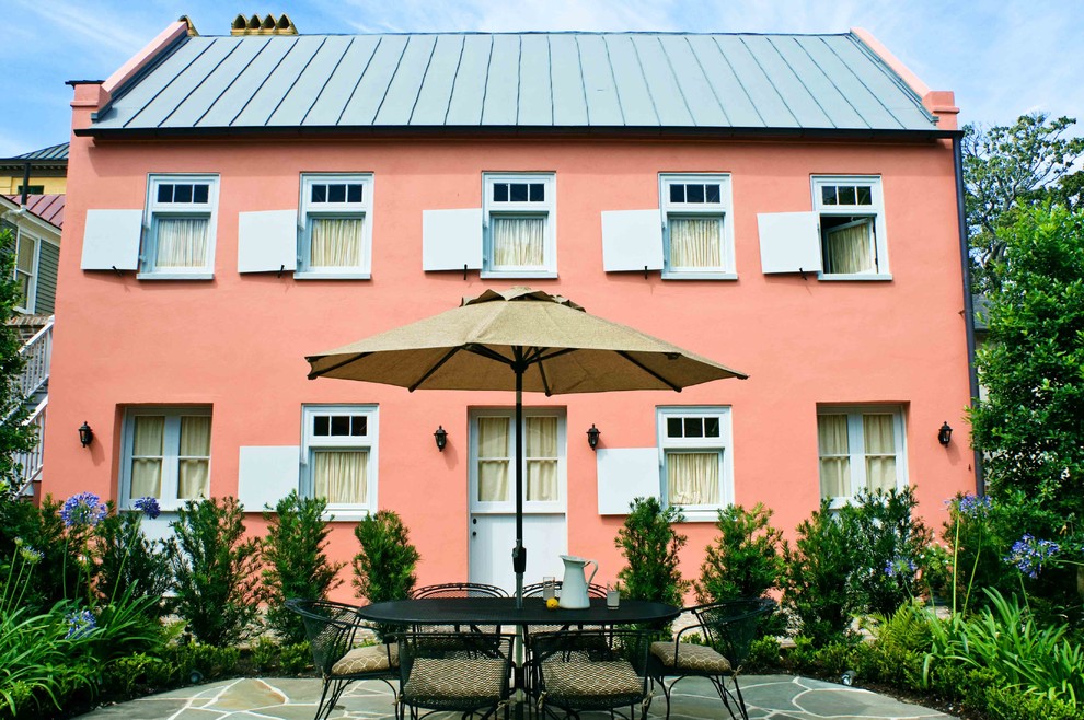 Photo of a mediterranean two-storey stucco pink exterior in Charleston.