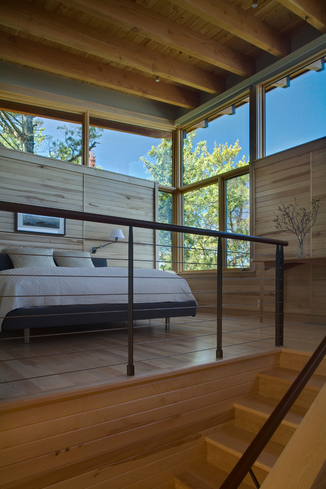 Small country loft-style bedroom in Seattle with light hardwood floors.