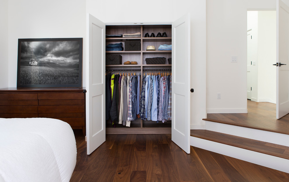 This is an example of a mid-sized contemporary men's built-in wardrobe in Nashville with open cabinets, dark wood cabinets and dark hardwood floors.