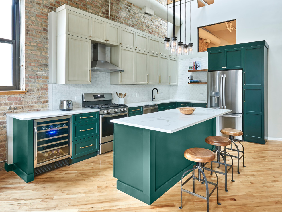Design ideas for a mid-sized industrial l-shaped kitchen in Chicago with recessed-panel cabinets, green cabinets, quartzite benchtops, with island, white benchtop, a single-bowl sink, stainless steel appliances and light hardwood floors.
