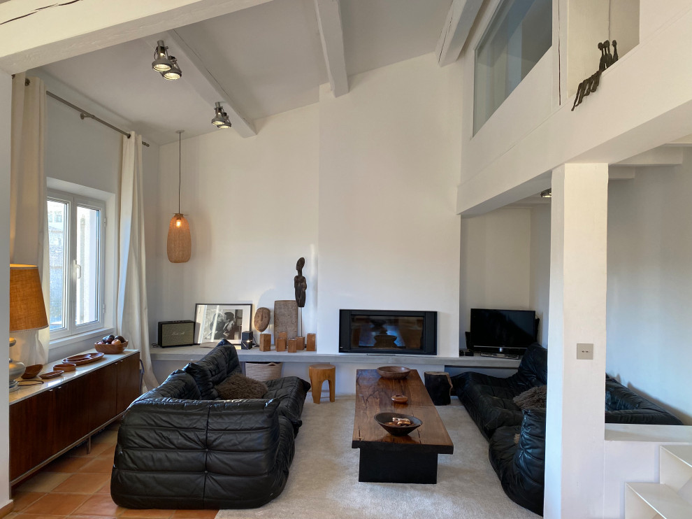 Пример оригинального дизайна: большая открытая гостиная комната в современном стиле с полом из терракотовой плитки, фасадом камина из штукатурки, балками на потолке и стандартным камином