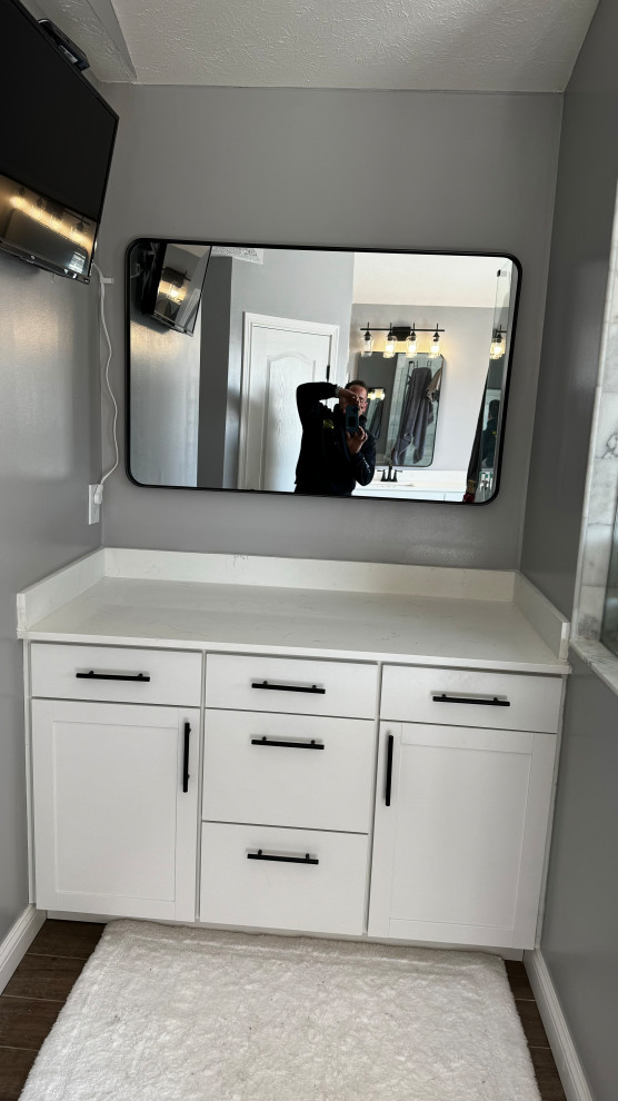 This is an example of a mid-sized country master bathroom in Cincinnati with flat-panel cabinets, white cabinets, grey walls, dark hardwood floors, engineered quartz benchtops, brown floor, white benchtops and a built-in vanity.