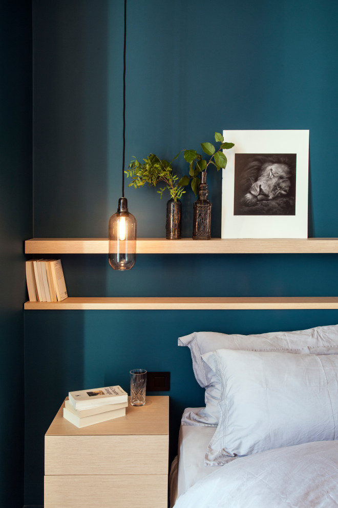 Inspiration pour une chambre parentale design de taille moyenne avec un mur bleu, un sol en bois brun, aucune cheminée, un sol beige et dressing.