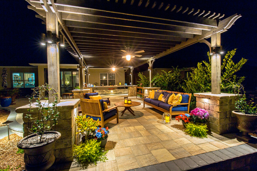 Expansive traditional backyard patio in Jacksonville with a fire feature, natural stone pavers and a pergola.