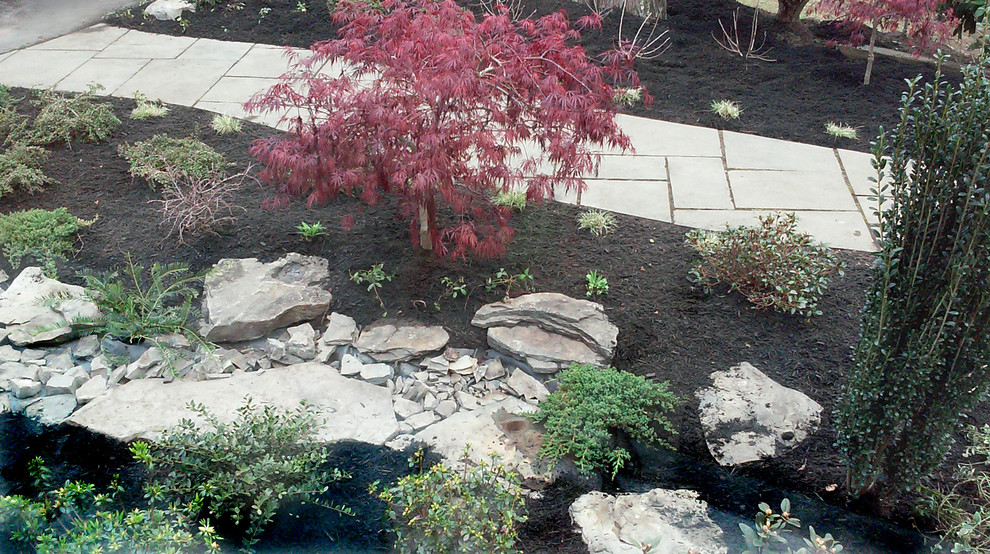 This is an example of a small modern front yard partial sun garden in New York with a water feature.
