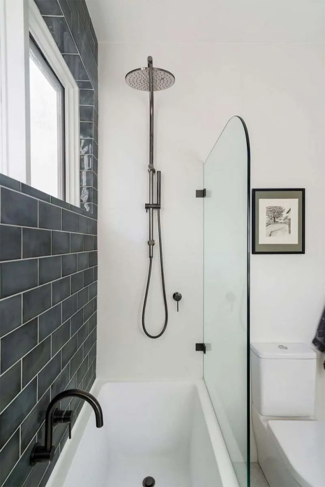This is an example of a small modern master bathroom in Perth with furniture-like cabinets, a drop-in tub, a shower/bathtub combo, a one-piece toilet, white tile, light hardwood floors, a vessel sink, engineered quartz benchtops, a hinged shower door, white benchtops, a single vanity, a floating vanity, recessed and brick walls.