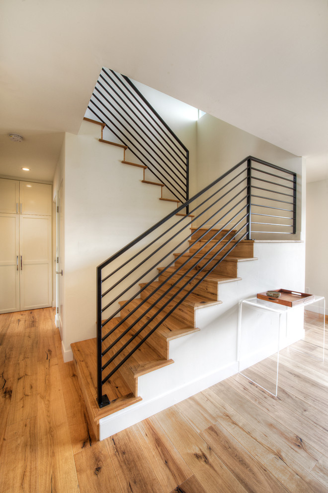 Inspiration for a mid-sized contemporary wood u-shaped staircase in San Diego with wood risers and metal railing.