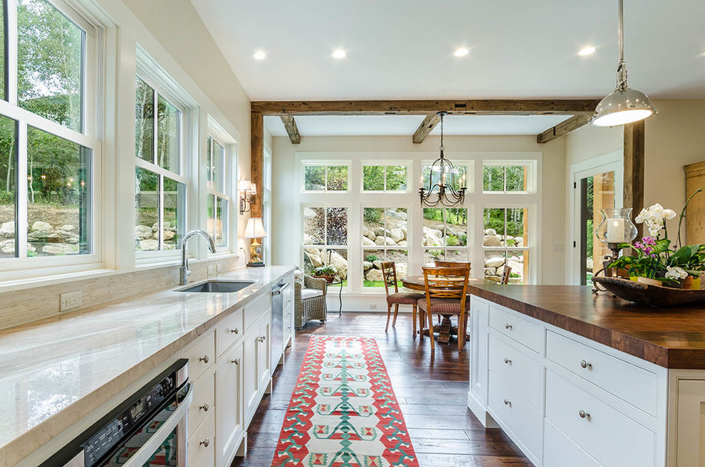 Example of a huge transitional l-shaped dark wood floor and brown floor eat-in kitchen design with an undermount sink, shaker cabinets, white cabinets, wood countertops, gray backsplash, matchstick tile backsplash, stainless steel appliances, an island and brown countertops