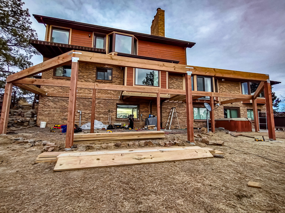 Example of a large minimalist backyard second story metal railing deck design in Denver with no cover