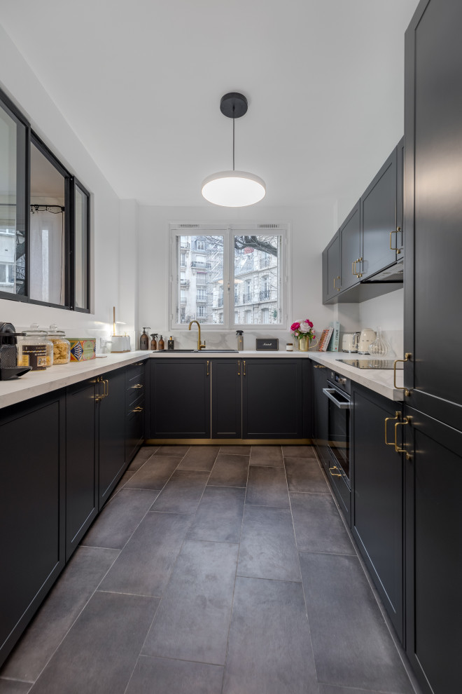 Design ideas for a mid-sized transitional u-shaped separate kitchen in Paris with a single-bowl sink, recessed-panel cabinets, black cabinets, laminate benchtops, white splashback, ceramic floors, grey floor and white benchtop.