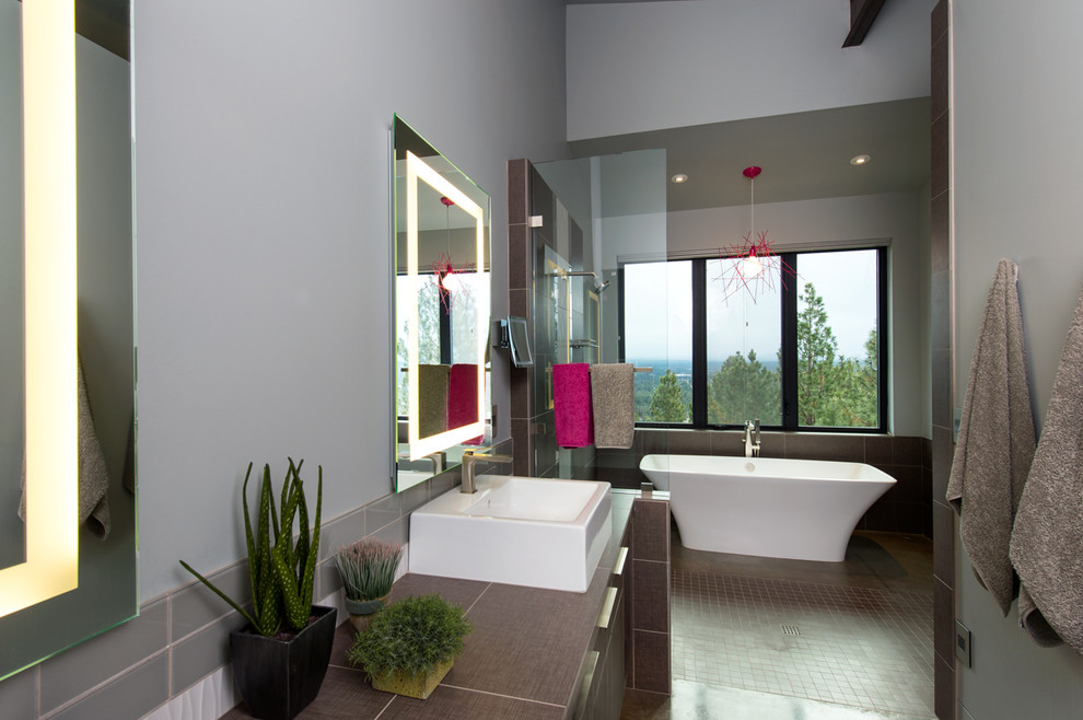 Photo of a large contemporary master bathroom in Other with a vessel sink, flat-panel cabinets, dark wood cabinets, solid surface benchtops, a freestanding tub, an open shower, brown tile and white walls.