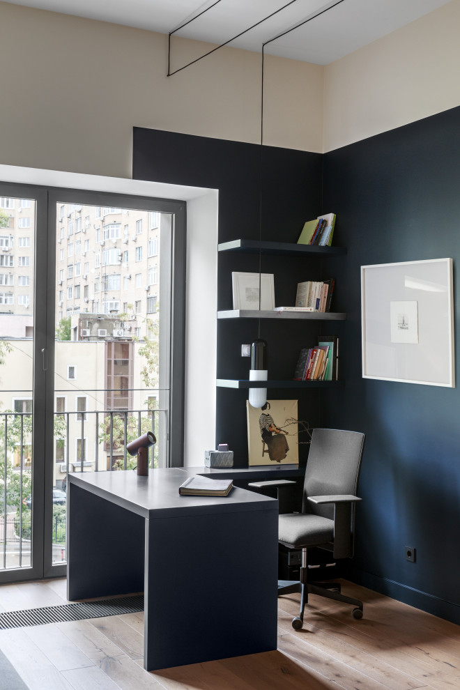 На фото: рабочее место в современном стиле с синими стенами и отдельно стоящим рабочим столом