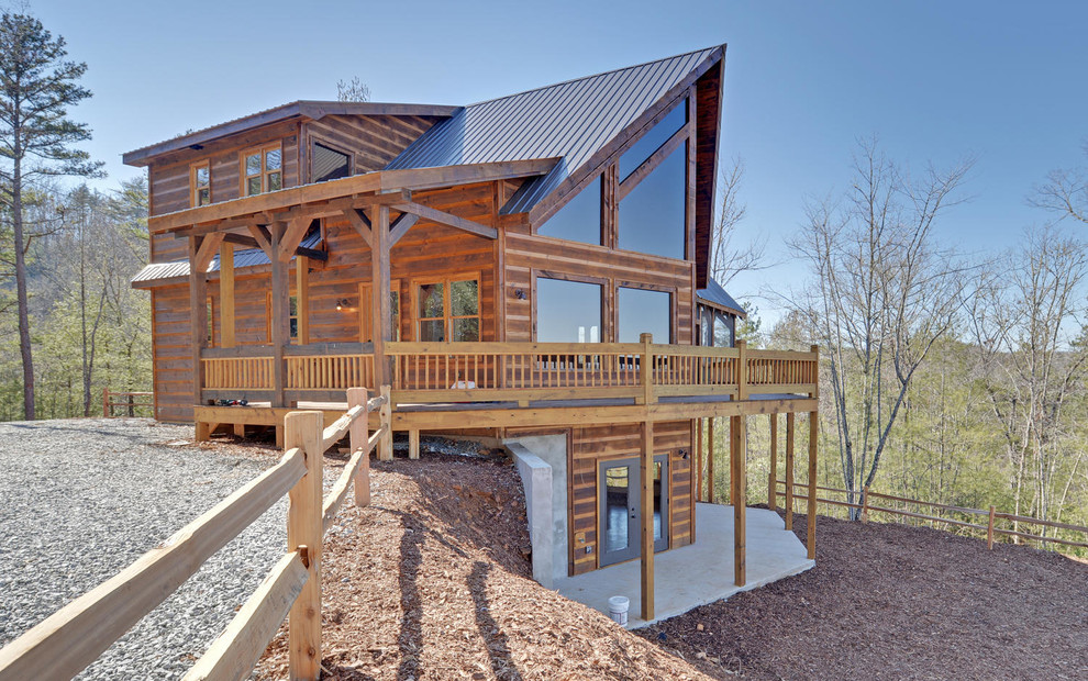 Photo of a mid-sized country three-storey brown house exterior in Atlanta with wood siding and a metal roof.