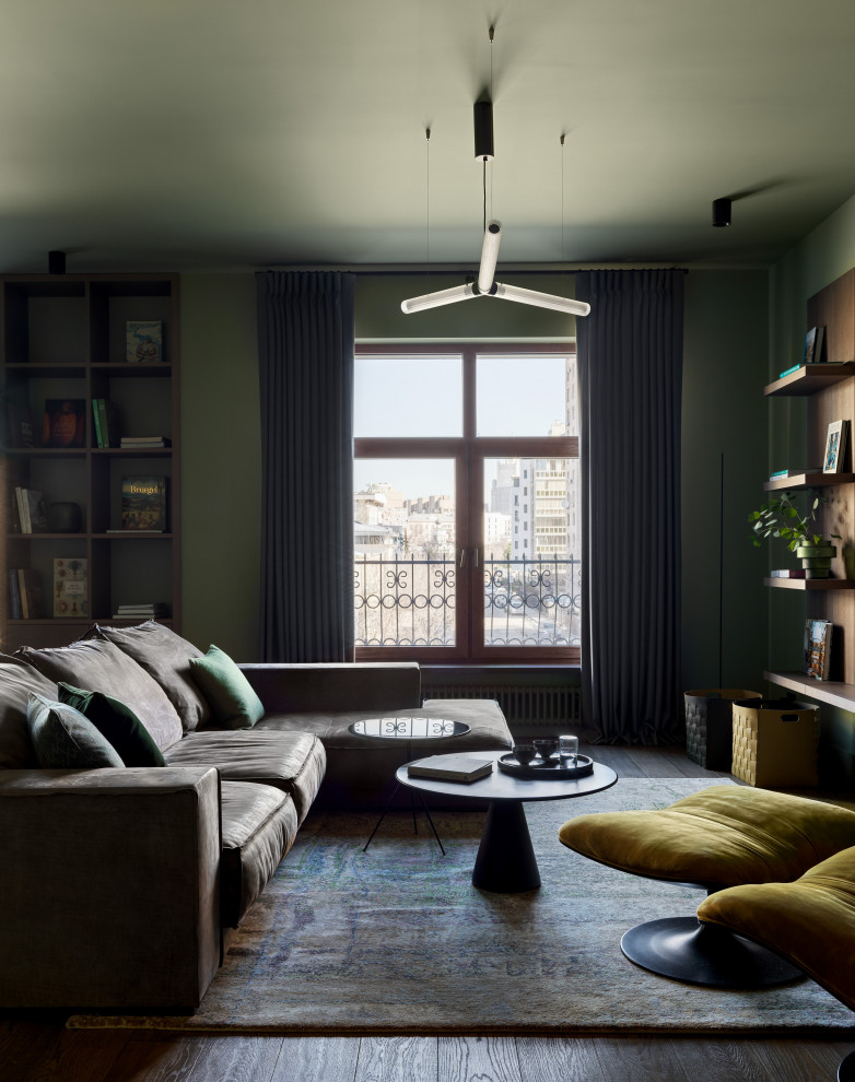 Источник вдохновения для домашнего уюта: большая открытая гостиная комната в современном стиле с зелеными стенами, темным паркетным полом, телевизором на стене и коричневым полом
