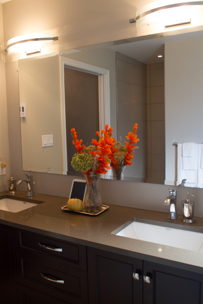 Example of a transitional bathroom design with an undermount sink, shaker cabinets, dark wood cabinets and quartz countertops