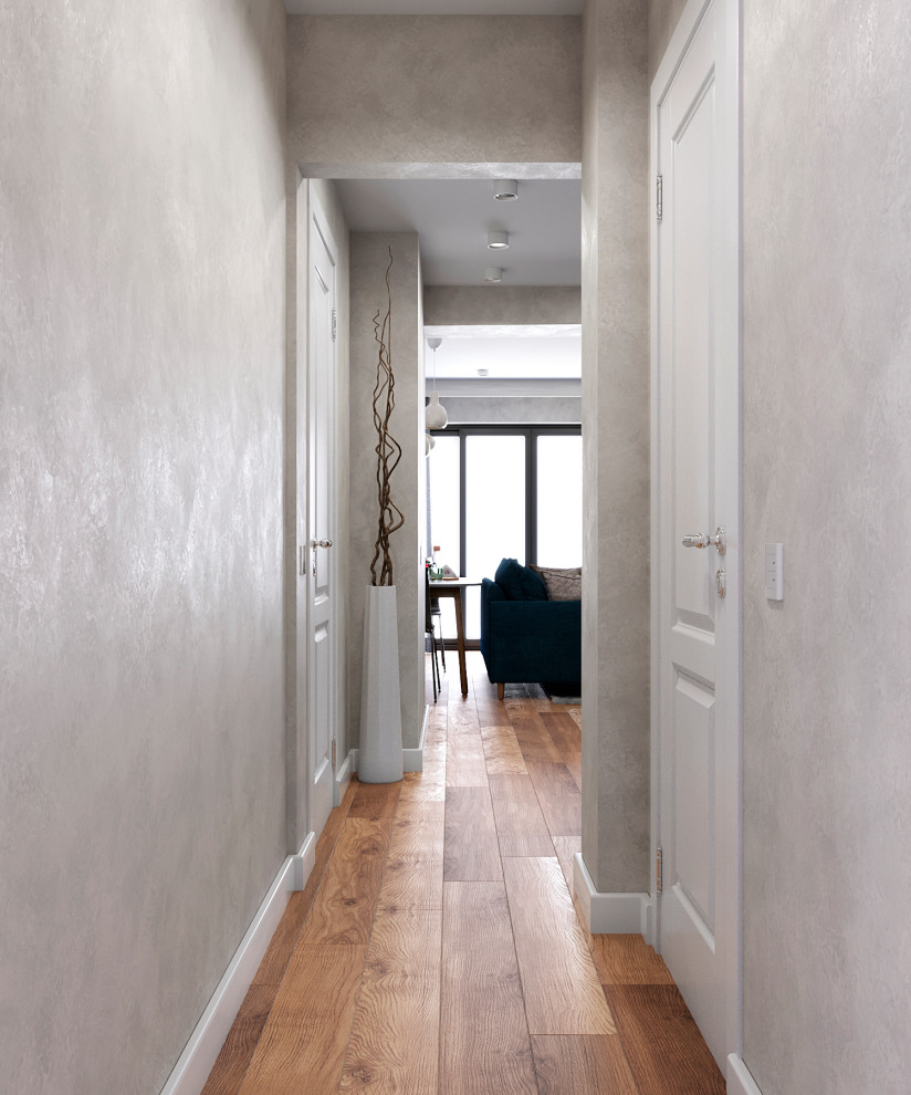 Aménagement d'un couloir contemporain avec un mur beige, sol en stratifié et un sol marron.