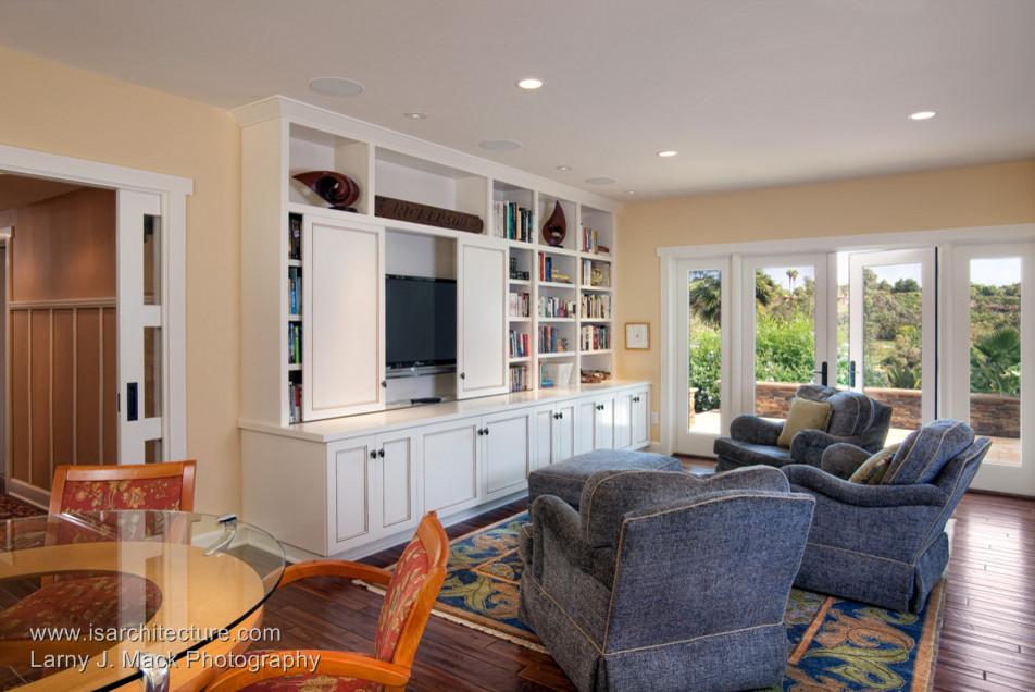 This is an example of a traditional family room in San Diego with beige walls, light hardwood floors and a wall-mounted tv.