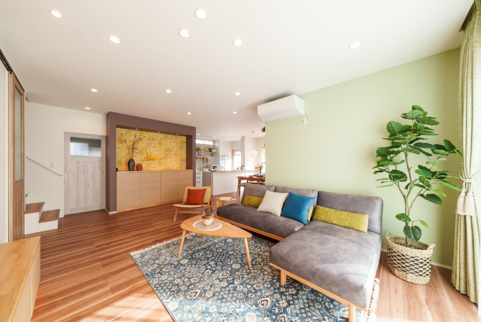 Immagine di un soggiorno con pareti marroni, pavimento in compensato, TV a parete, pavimento beige, soffitto in carta da parati e carta da parati