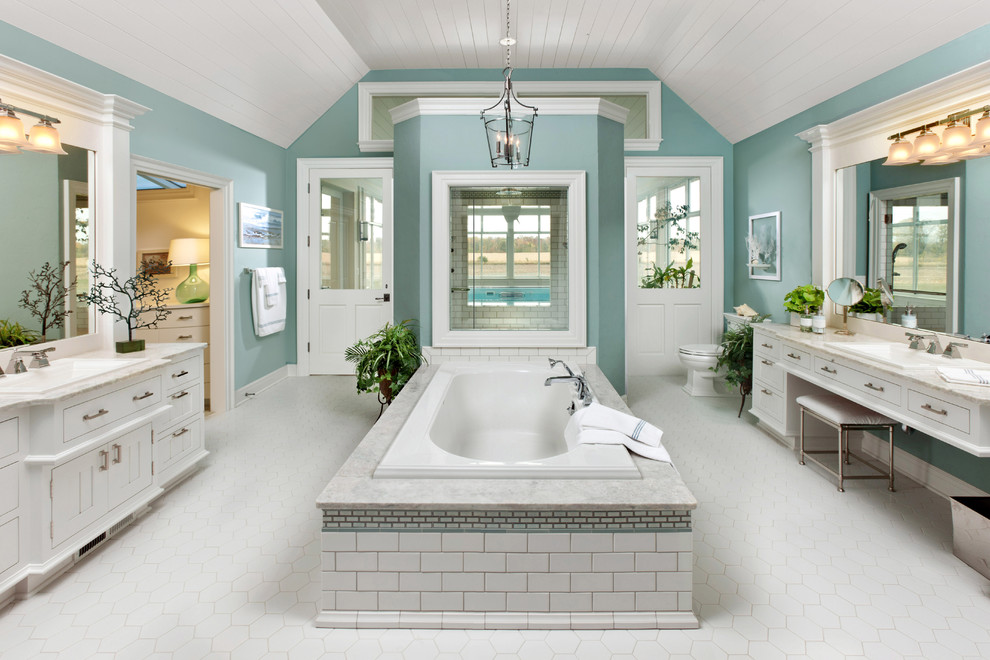Design ideas for a large traditional master bathroom in Milwaukee with a drop-in tub, white tile, a drop-in sink, flat-panel cabinets, white cabinets, granite benchtops, a one-piece toilet, ceramic tile, green walls, ceramic floors and beige benchtops.