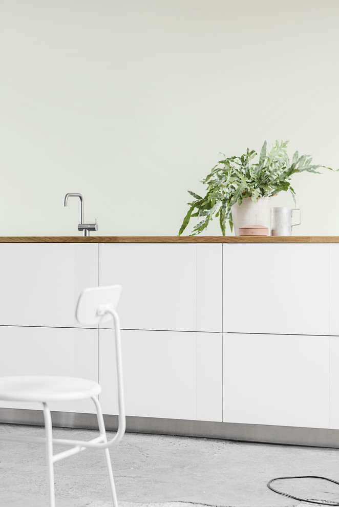 Inspiration for a scandinavian kitchen in Copenhagen with white cabinets, wood benchtops and with island.