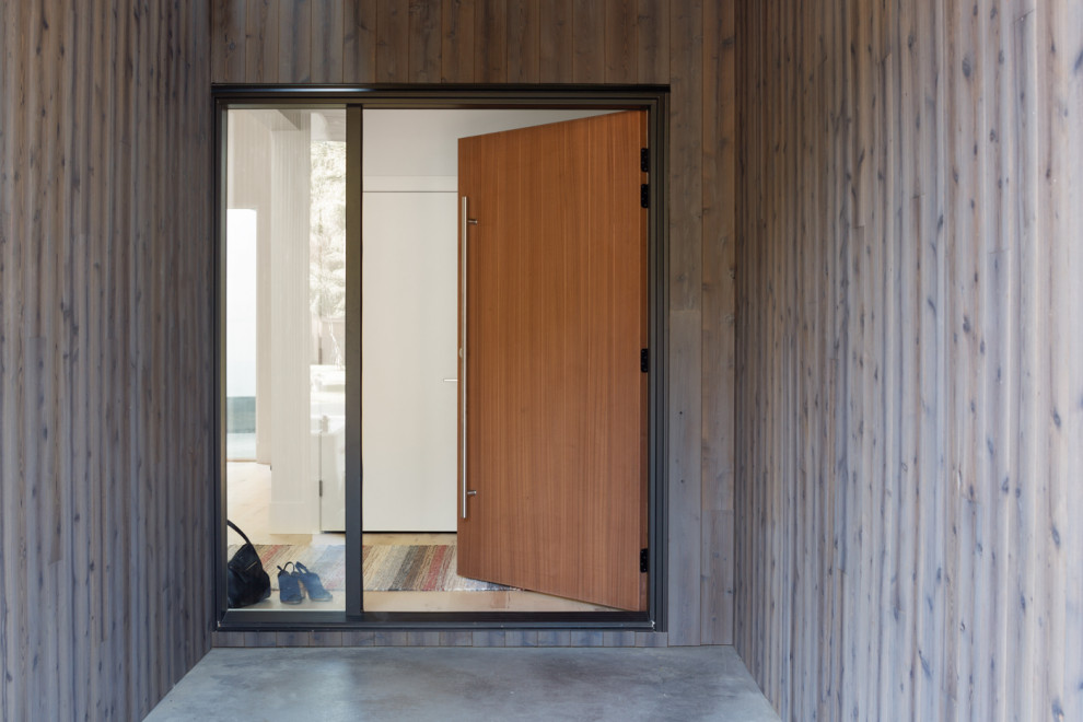 Mid-sized midcentury front door in Vancouver with grey walls, concrete floors, a single front door, a medium wood front door and grey floor.