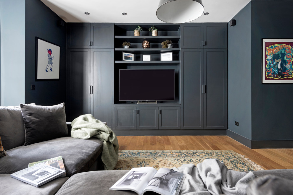 Inspiration for a small contemporary home theatre in London with grey walls, light hardwood floors, a wall-mounted tv and brown floor.
