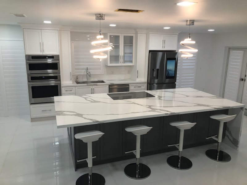 Eat-in kitchen - transitional single-wall porcelain tile and white floor eat-in kitchen idea in Miami with an undermount sink, shaker cabinets, white cabinets, quartz countertops, white backsplash, mosaic tile backsplash, stainless steel appliances and an island