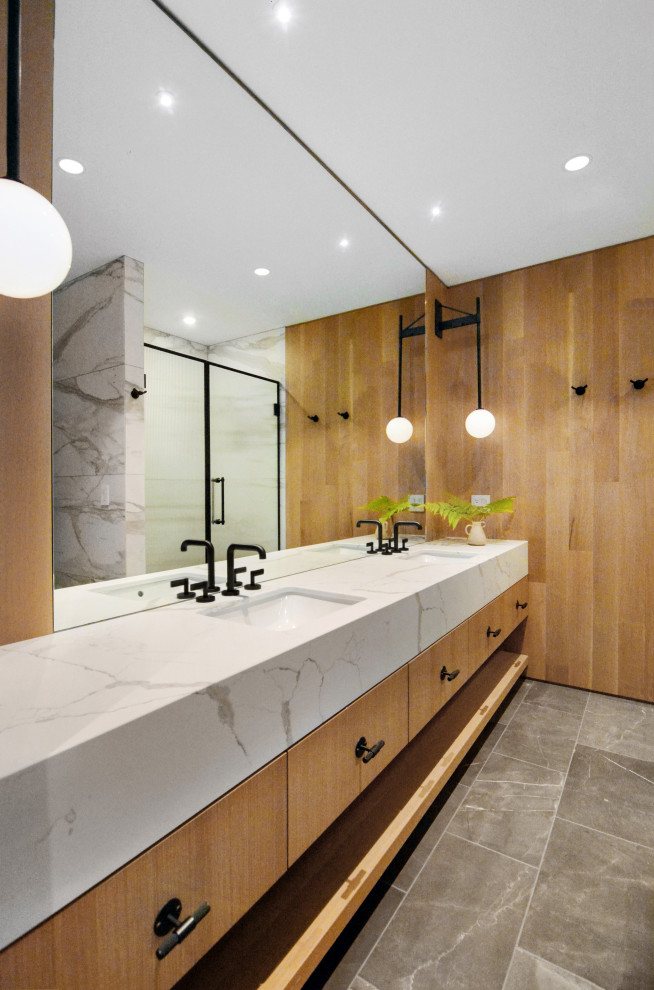 Photo of a large contemporary master bathroom in Other with flat-panel cabinets, white cabinets, an alcove shower, a one-piece toilet, white tile, marble, brown walls, slate floors, an undermount sink, marble benchtops, grey floor, a hinged shower door, white benchtops, a shower seat, a double vanity, a built-in vanity and wood walls.