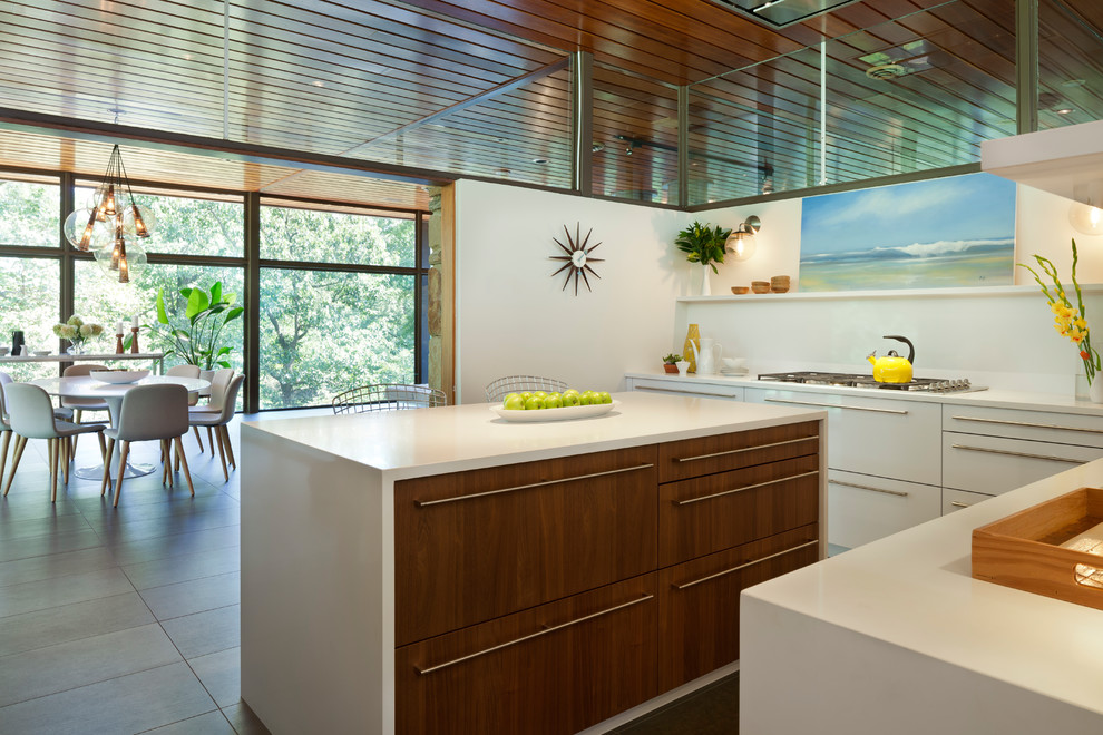 This is an example of a mid-sized midcentury l-shaped kitchen pantry in DC Metro with an undermount sink, flat-panel cabinets, white cabinets, laminate benchtops, white splashback, with island and brown floor.