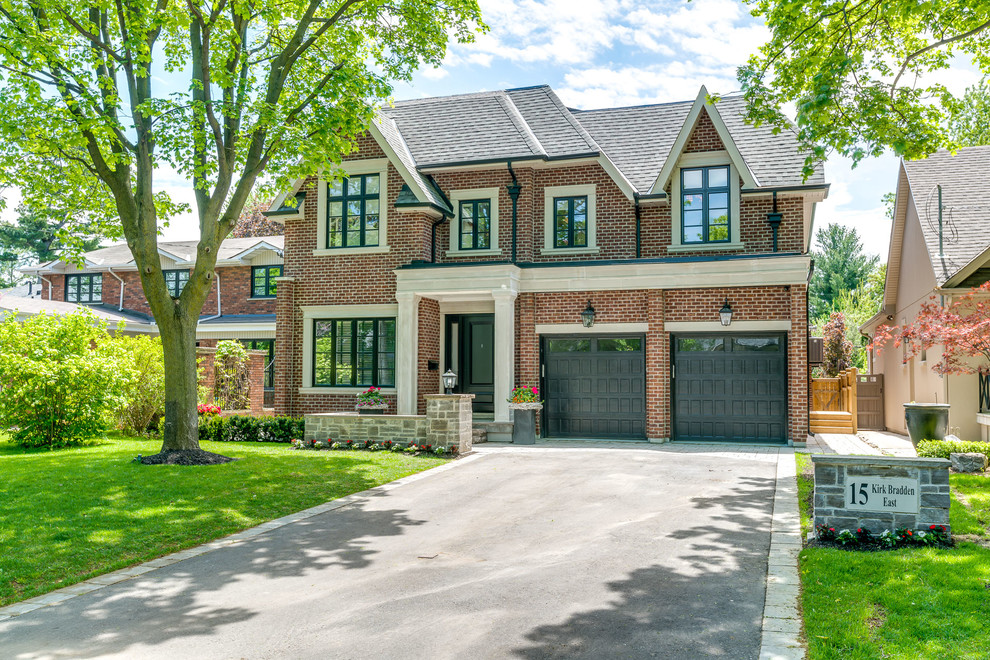 Large traditional two-storey brick red house exterior in Toronto with a shingle roof.