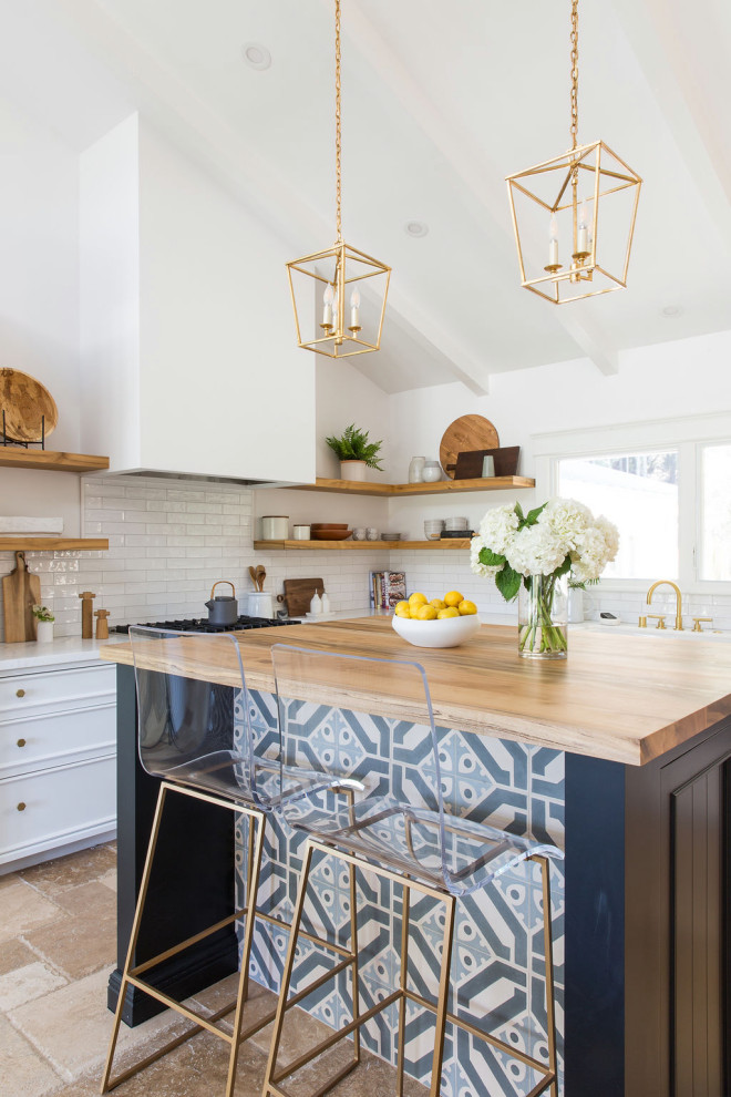 Design ideas for a contemporary l-shaped kitchen in San Francisco with recessed-panel cabinets, white cabinets, white splashback, stainless steel appliances, with island, beige floor, white benchtop, exposed beam, vaulted, a farmhouse sink, marble benchtops and travertine floors.