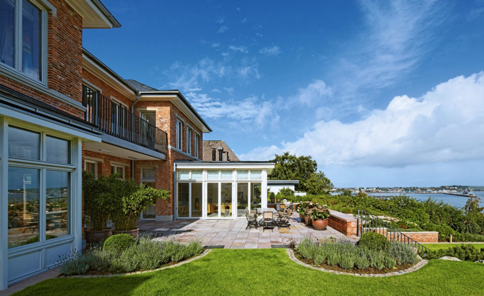 Großer, Unbedeckter Klassischer Patio mit Kübelpflanzen und Sonnenschutz in Sonstige