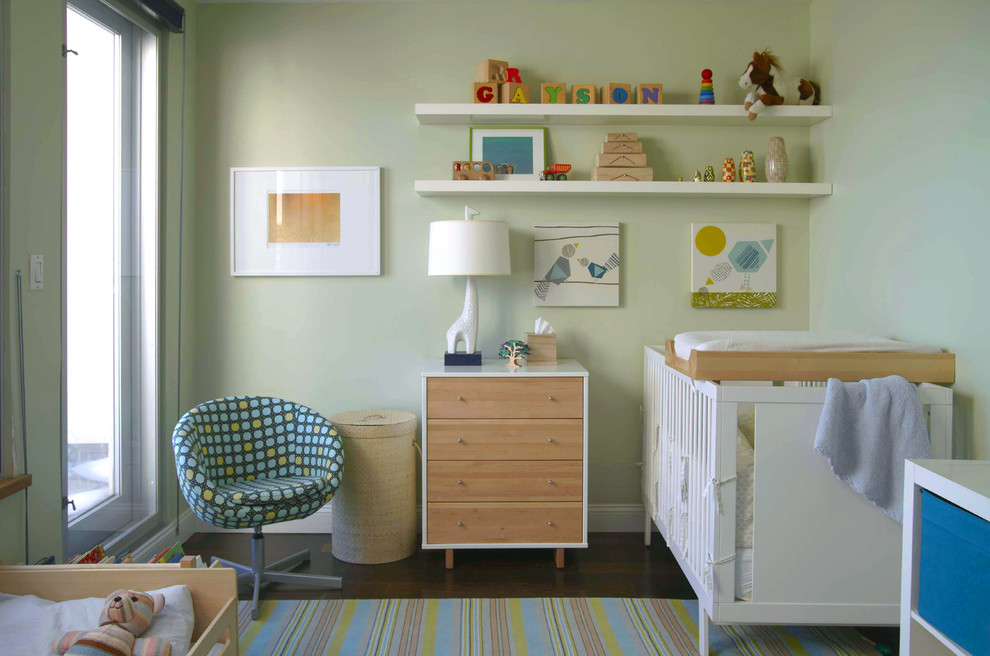 Design ideas for a modern nursery for boys in New York with green walls and dark hardwood floors.