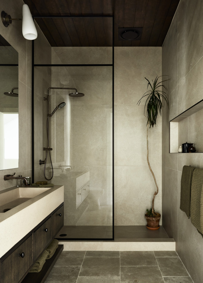 Пример оригинального дизайна: маленькая главная ванная комната с плоскими фасадами, темными деревянными фасадами, открытым душем, унитазом-моноблоком, бежевой плиткой, плиткой из известняка, бежевыми стенами, полом из известняка, раковиной с несколькими смесителями, столешницей из бетона, бежевым полом, открытым душем, бежевой столешницей, тумбой под две раковины, подвесной тумбой и потолком из вагонки для на участке и в саду