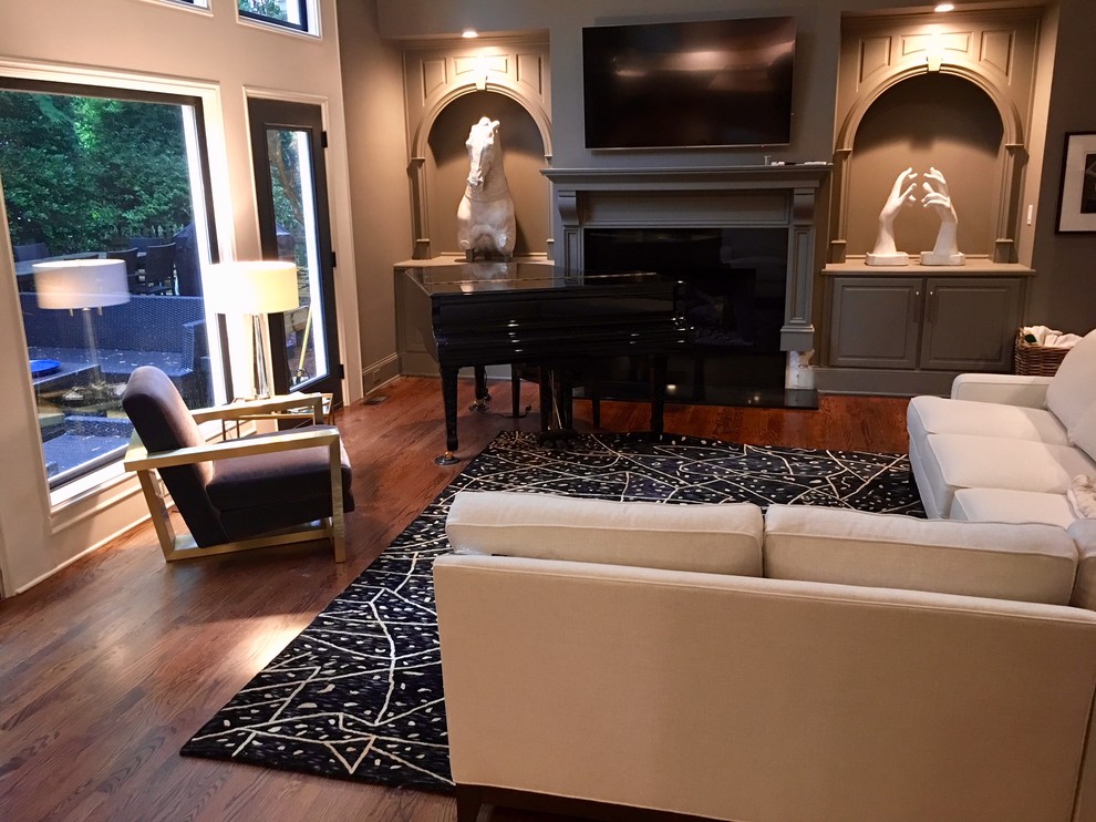Large contemporary open concept living room in Atlanta with a music area, grey walls, medium hardwood floors and a standard fireplace.