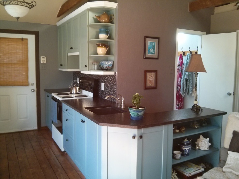 Inspiration for a small rustic l-shaped dark wood floor and brown floor open concept kitchen remodel with an undermount sink, shaker cabinets, green cabinets, granite countertops, metallic backsplash, mosaic tile backsplash, white appliances and no island