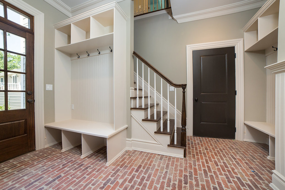 Design ideas for a large transitional mudroom in New York with grey walls, brick floors, a single front door and a dark wood front door.
