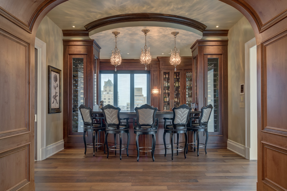 Inspiration for a large traditional home bar in Philadelphia with dark hardwood floors, glass-front cabinets and dark wood cabinets.