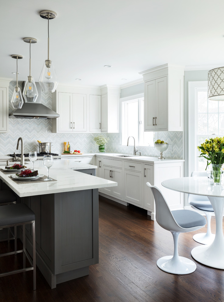 Design ideas for a transitional l-shaped eat-in kitchen in New York with an undermount sink, shaker cabinets, white cabinets, multi-coloured splashback, dark hardwood floors, with island, brown floor and white benchtop.