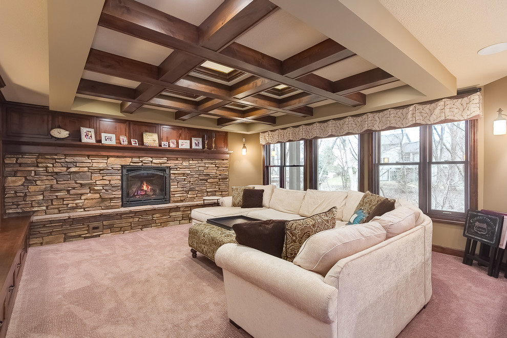 This is an example of a mid-sized traditional look-out basement in Minneapolis with beige walls, carpet, a standard fireplace, a stone fireplace surround and beige floor.