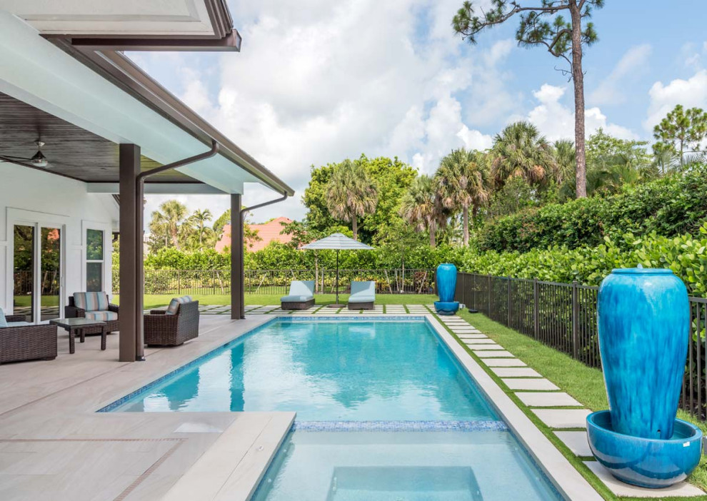 Mediterranean backyard l-shaped pool in Miami with a hot tub.