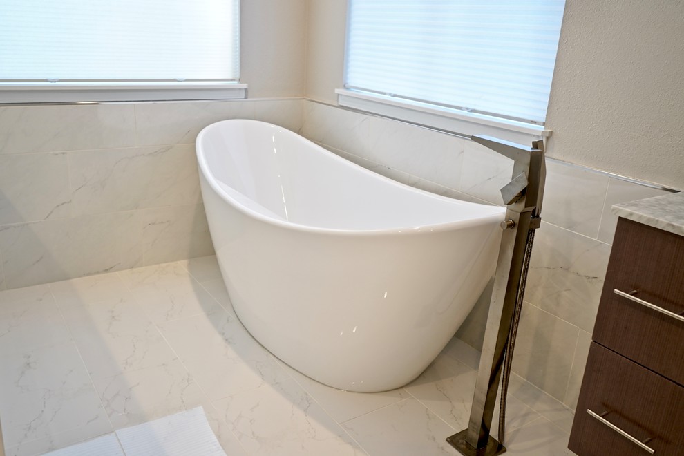 Large modern master bathroom in Seattle with a freestanding tub, white tile, white walls, marble benchtops, a hinged shower door, recessed-panel cabinets, medium wood cabinets, ceramic tile, ceramic floors and grey benchtops.