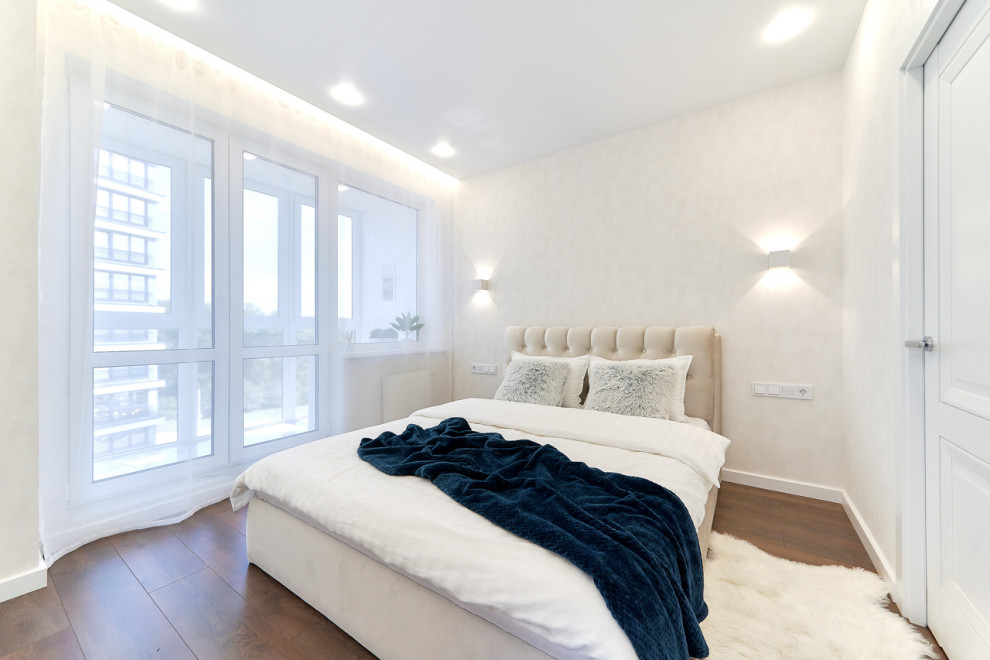 Пример оригинального дизайна: хозяйская спальня среднего размера: освещение в современном стиле с белыми стенами, полом из ламината, коричневым полом и обоями на стенах без камина
