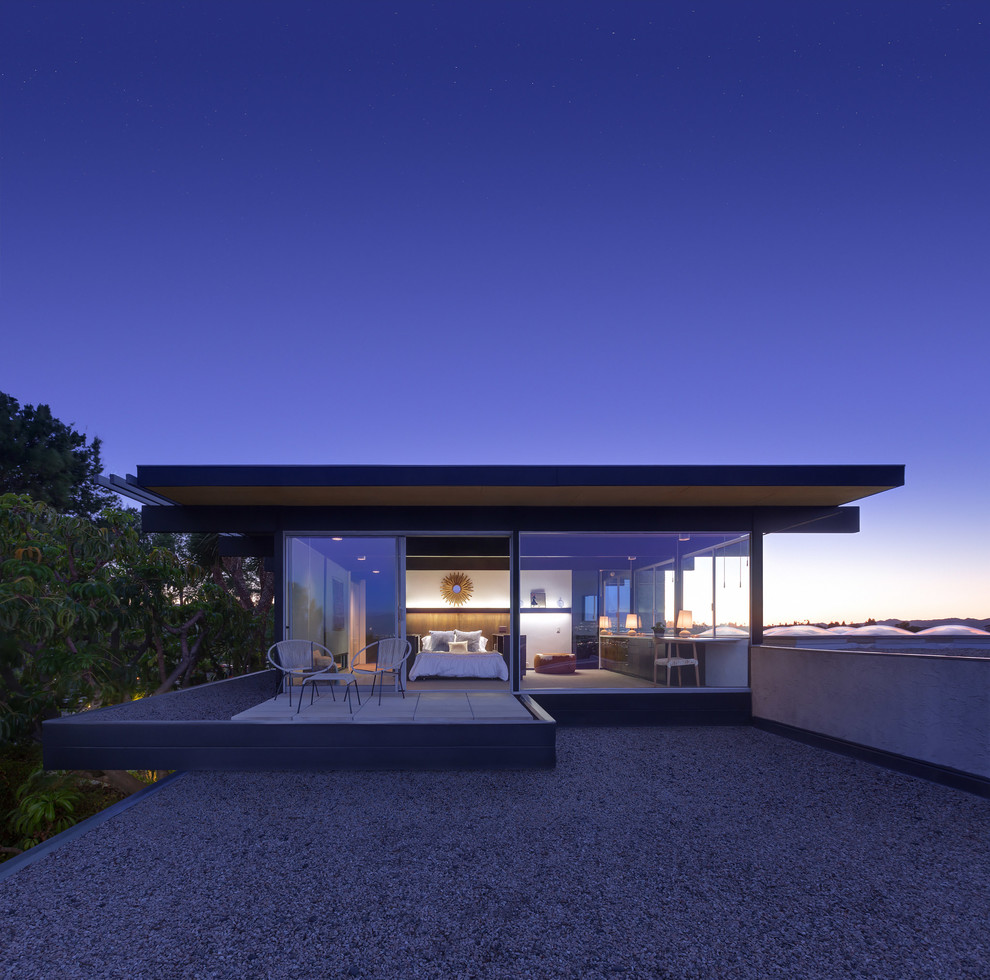 Inspiration for a modern two-storey glass house exterior in Los Angeles with a flat roof.