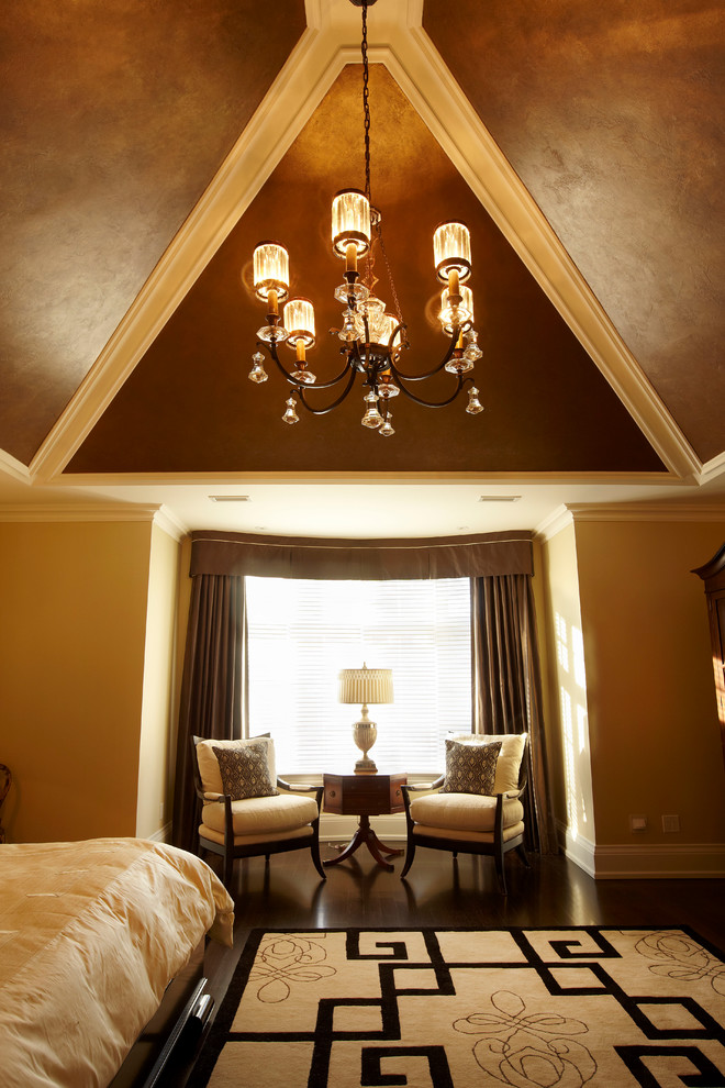 This is an example of a large traditional master bedroom in Toronto with beige walls and dark hardwood floors.